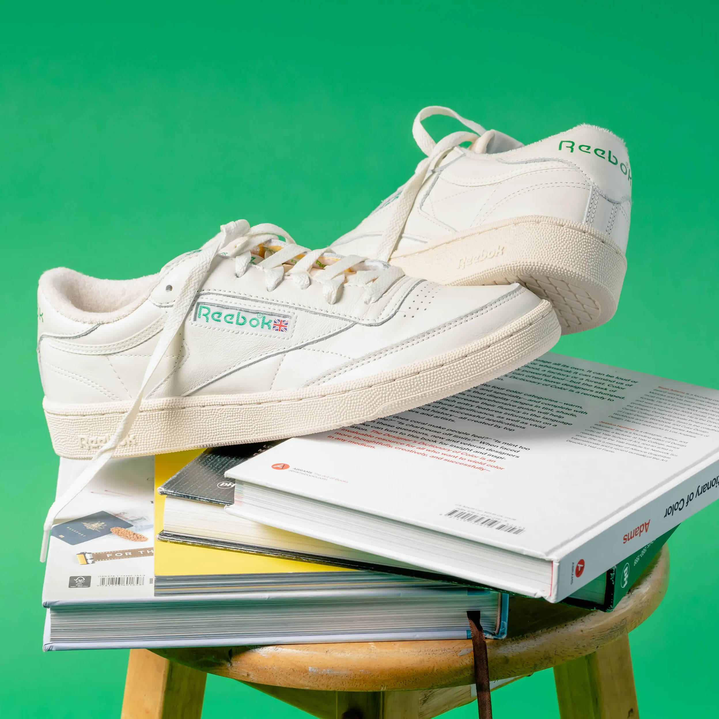 white reebok shoes on top of textbooks