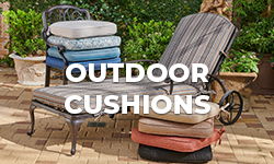 Outdoor cushions arranged on a lounge chair in a garden setting.