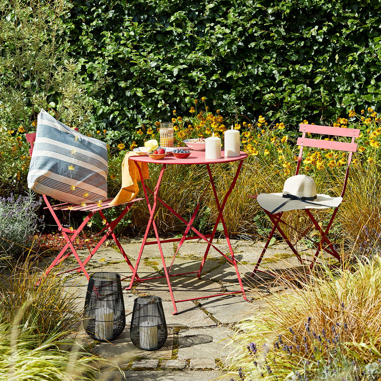 Alfresco dining setting on patio with Melbourne lantern duo sat on floor and TruGlow candles on table
