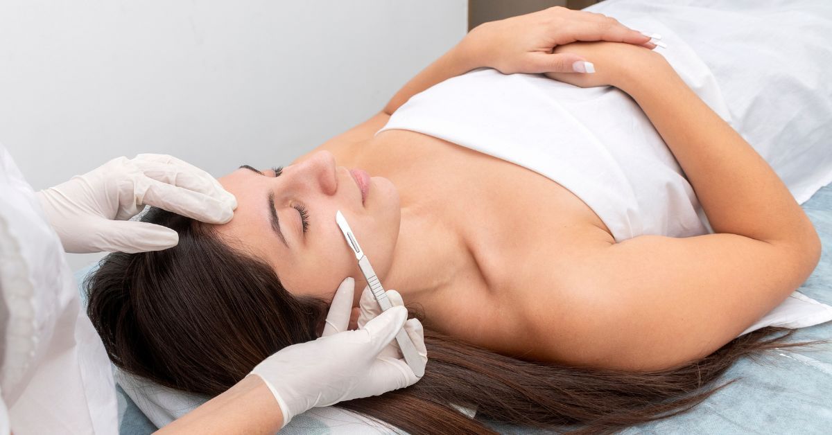 A woman receiving a dermaplaning treatment in a spa setting.