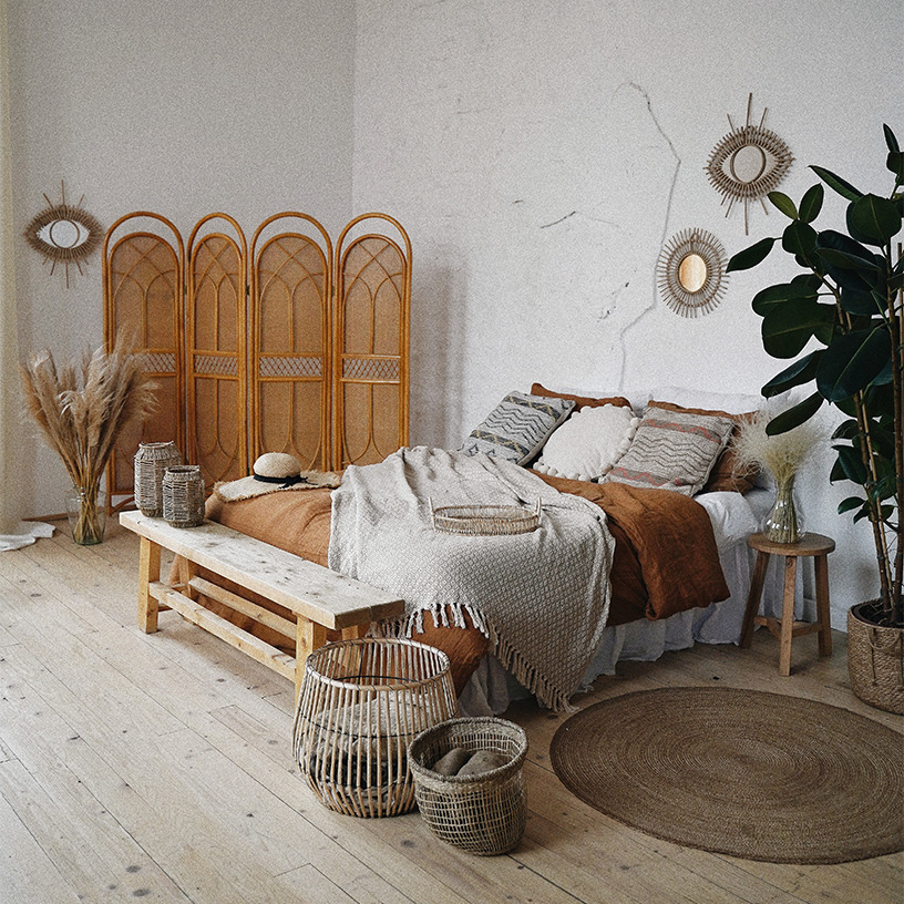 A trendy and rustic furnished room with a bed in the center.