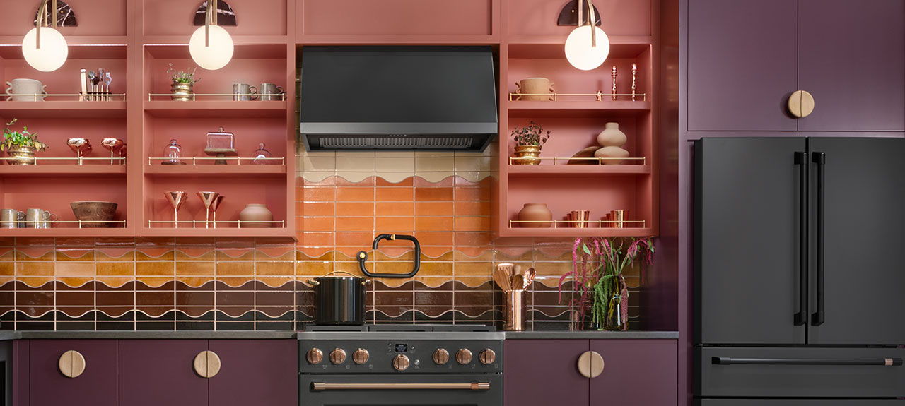 Kitchen with purple cabinets, matte black appliances, and colorful backsplash.
