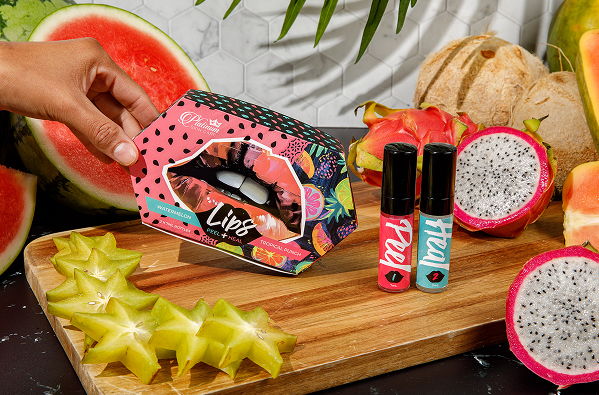 Colorful lip kit with fruit background on a wooden cutting board.