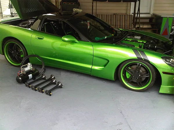 Garage install lime green Corvette hood open horn kit compressor trumpets on floor Rajiv's 2008 Chevrolet Corvette Conductor's Special 228H customer install gallery photo 2