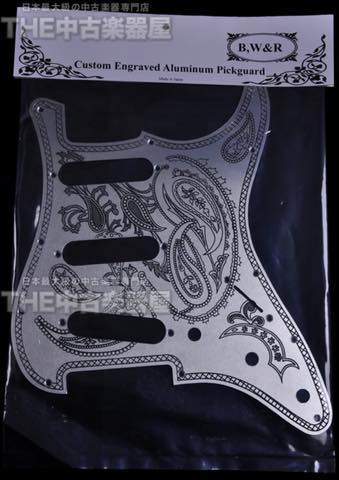 Custom engraved aluminum guitar pickguard with intricate design.