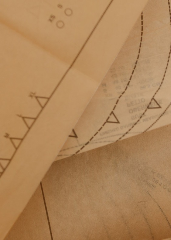 Blueprints or patterns on folded paper with geometric shapes and lines.