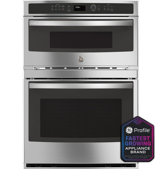Stainless steel double oven with controls and a branding badge.