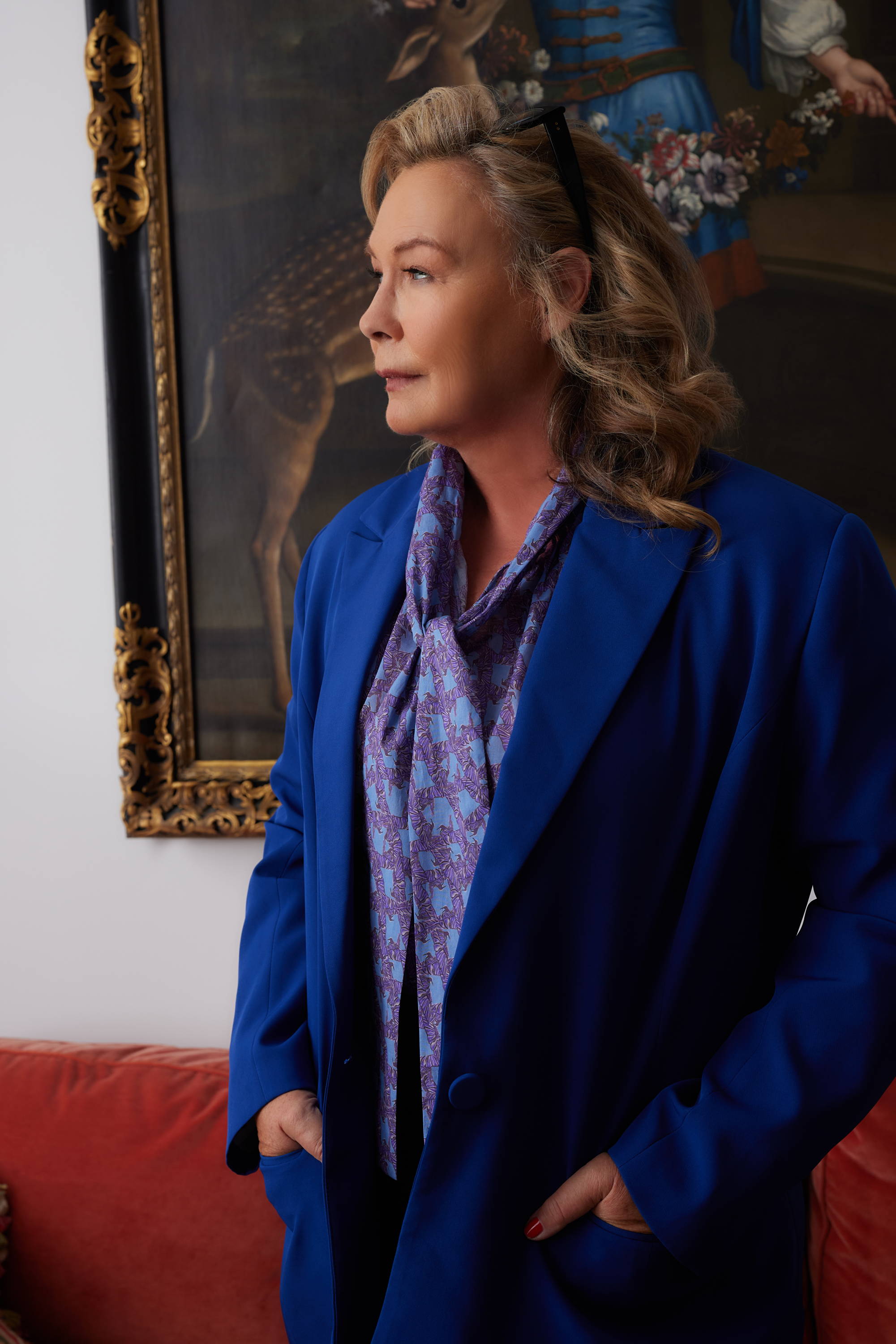 Ala Isham wearing blue silk lined suit over bow tie neck cotton blouse at her apartment in New York City