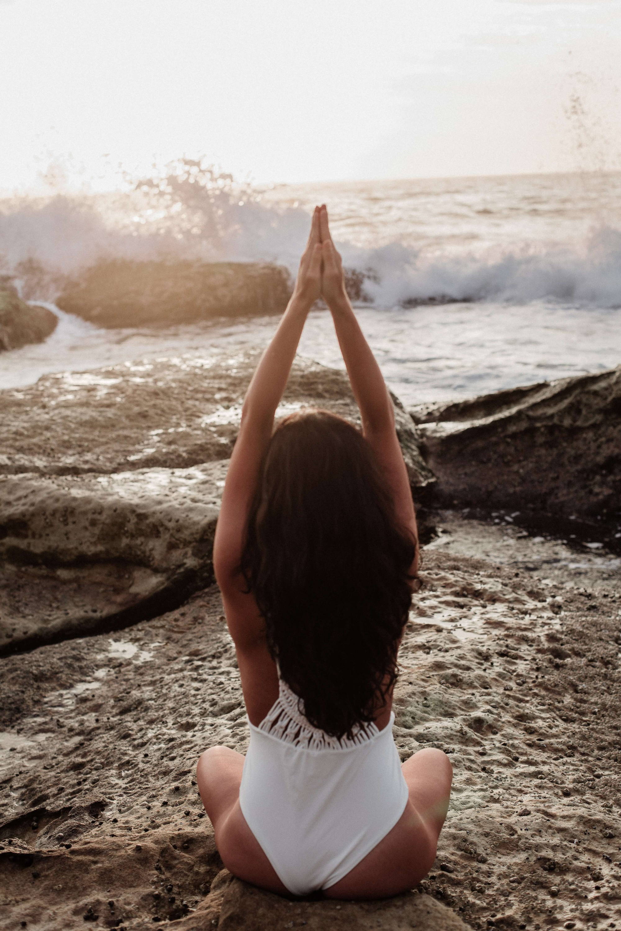 Woman doing yoga on the beach