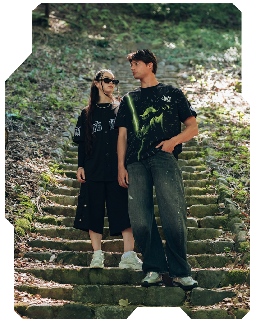 A couple standing on stone steps in a forested area.