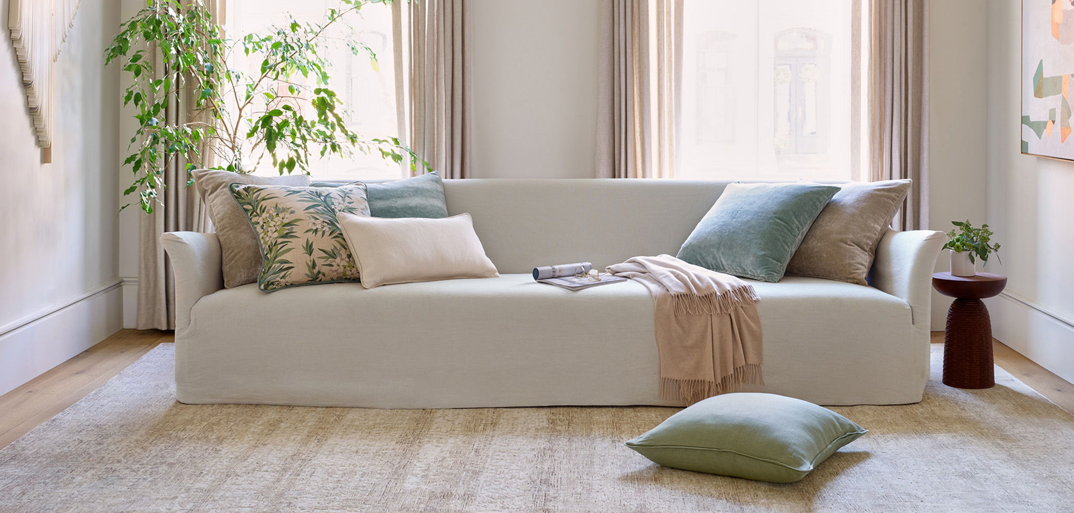 A cozy living room with Galaxy rug and a white sofa and decorative pillows.