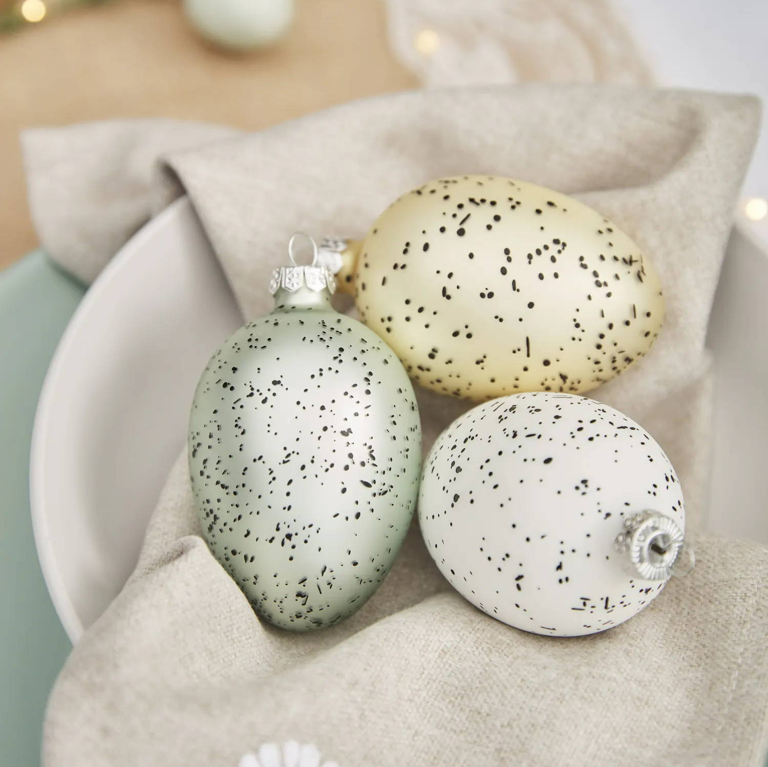 Set of 3 pastel Easter egg decorations on dining table place setting 