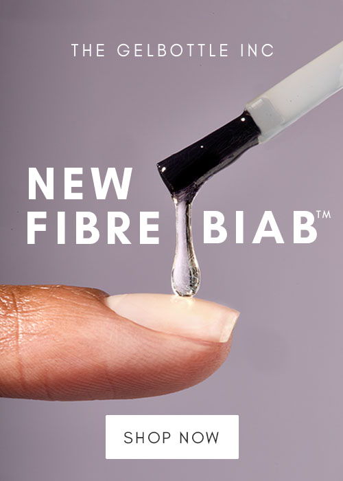 Finger with nail polish brush dripping product labeled 