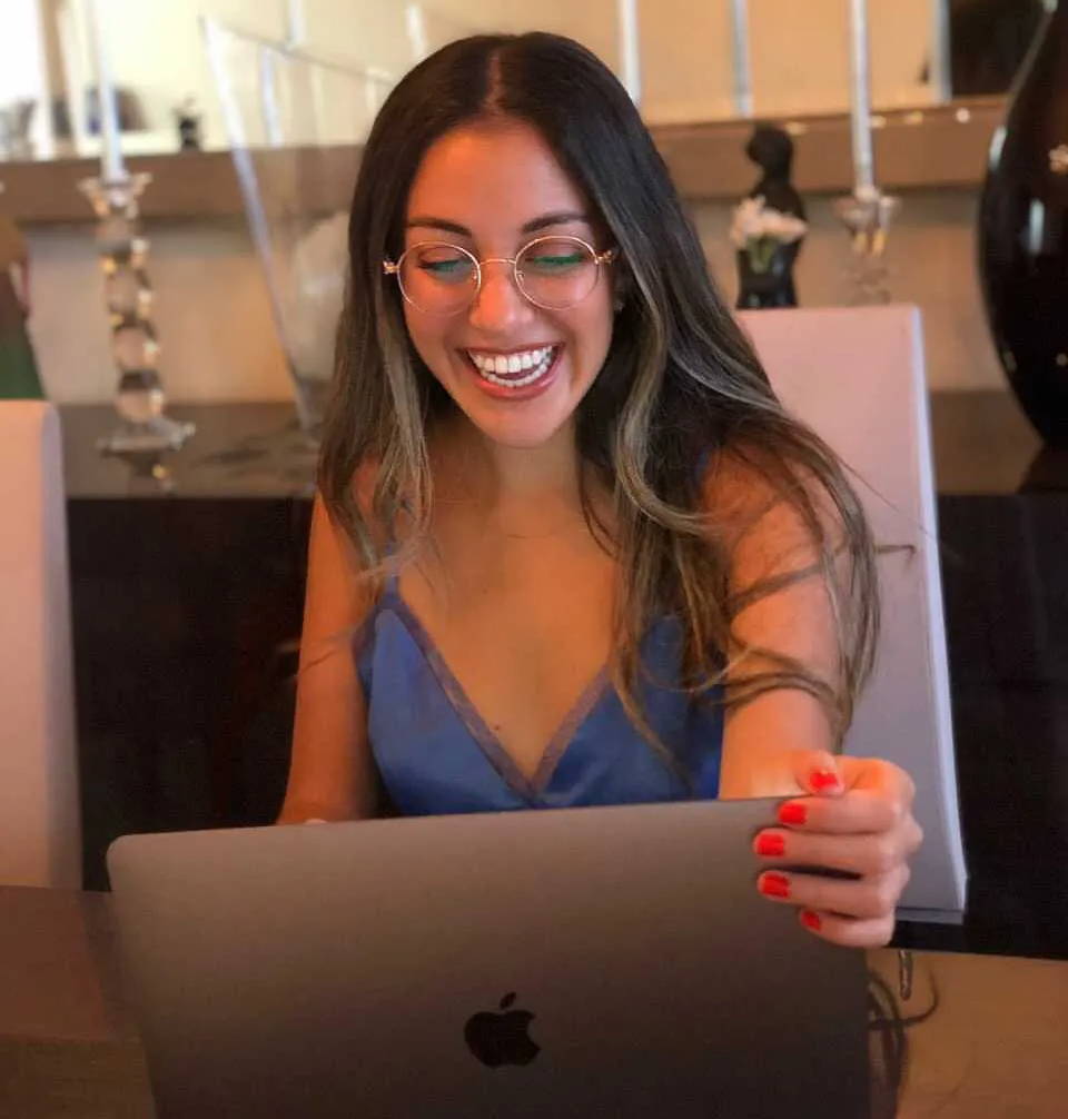Woman wearing Joy Rose Gold, Blue light computer glasses while working on her laptop