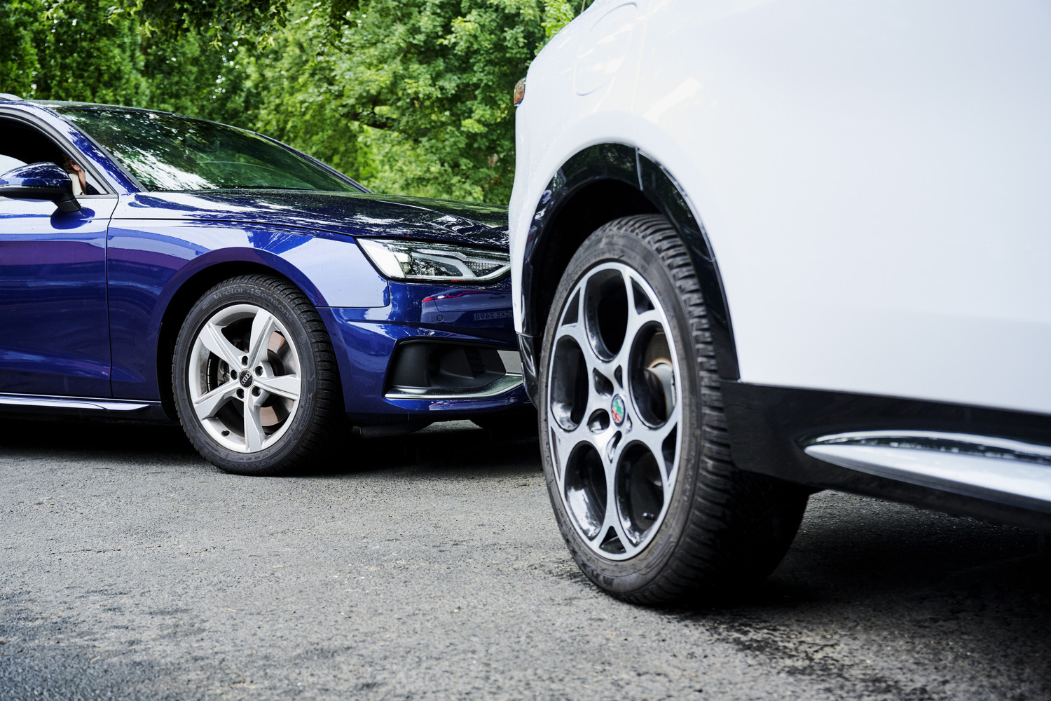 Two cars parked close together, focusing on the wheels and tires.
