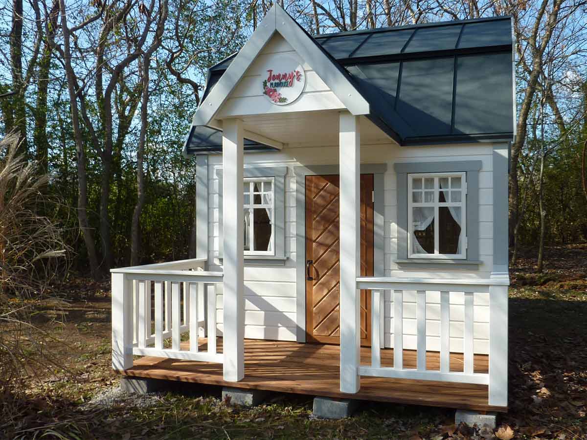 White and light gray Wooden Playhouse with natural color fishbone door, wooden terrace with white railing by WholeWoodPlayhouses
