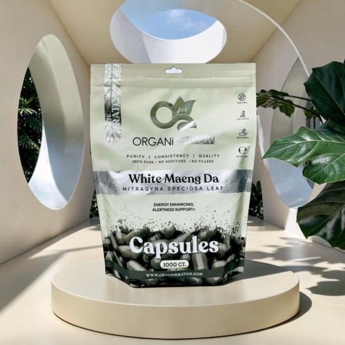 Organic White Maeng Da capsules package on a display with greenery.