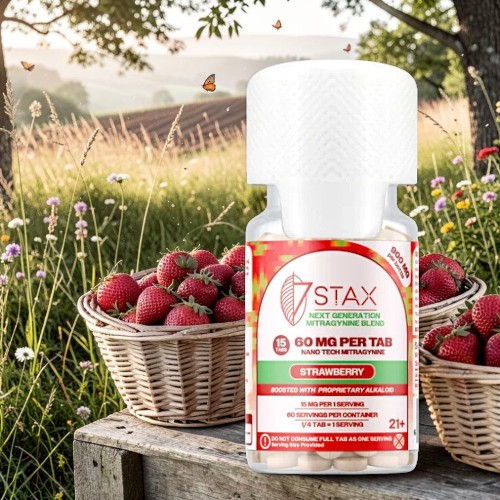 Bottle of STAX product in front of baskets of strawberries.