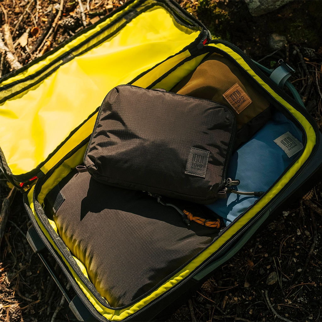 Open suitcase containing various packed items in organized layers.