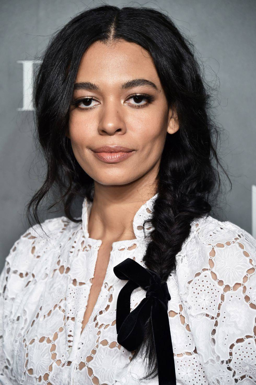 Woman with dark brunette hair and a loosely ribbon tied braid