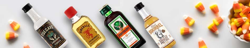 Bottles of various cooking oils and colorful candy corn on a surface.