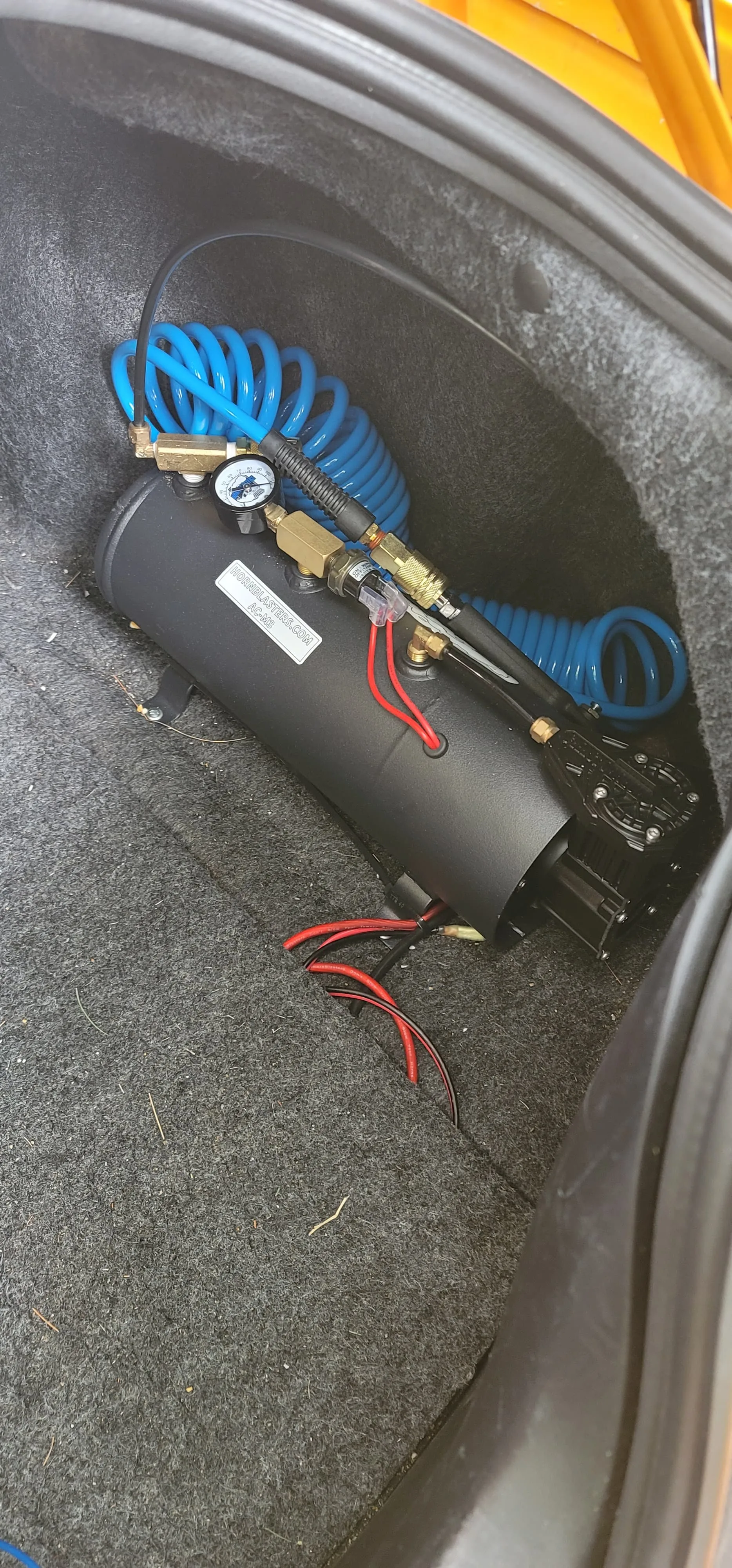 Close-up of black air horn hardware mounted under car