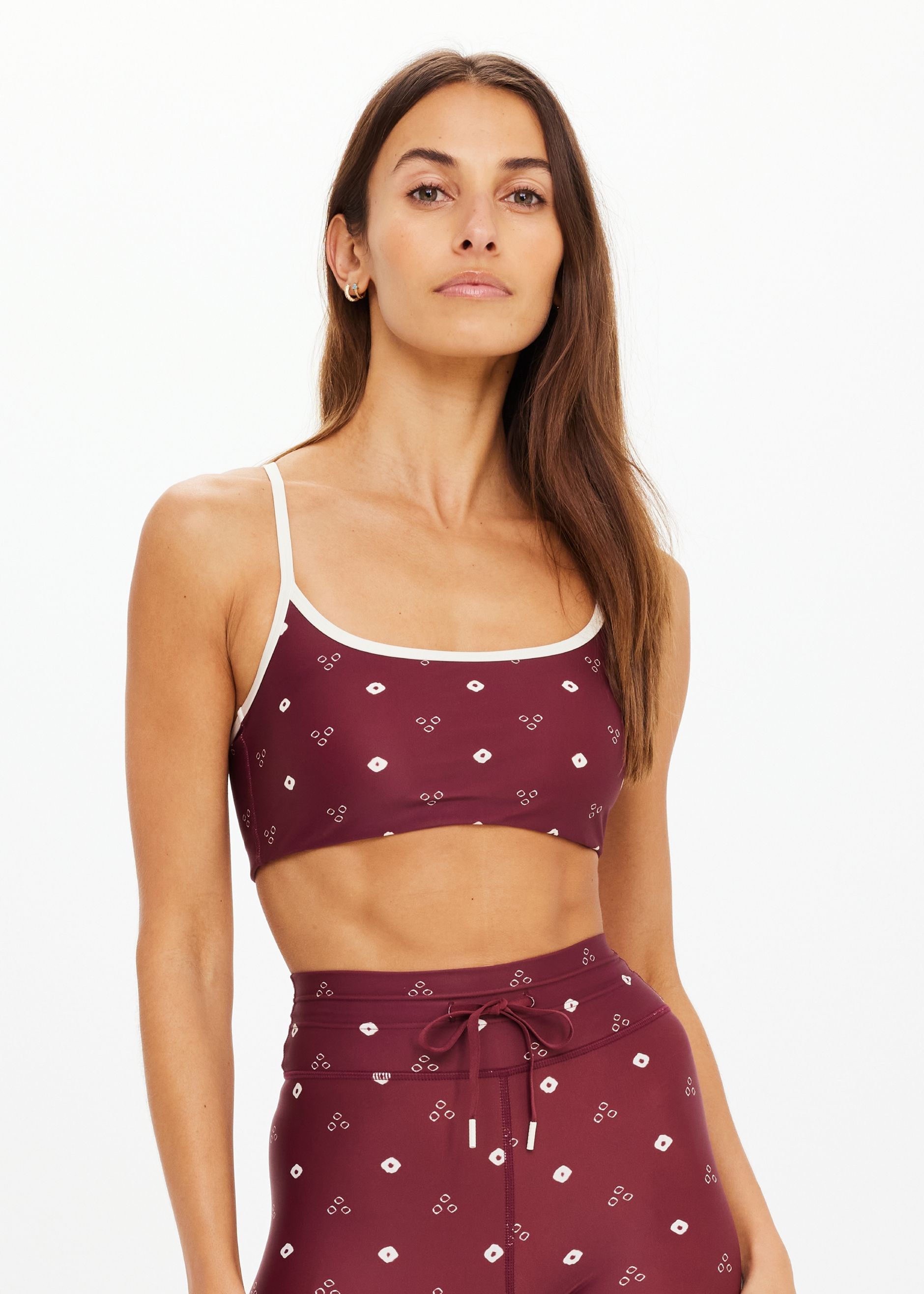 Woman wearing a maroon crop top and matching pants.