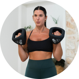 Woman lifting YBell in a workout setting.