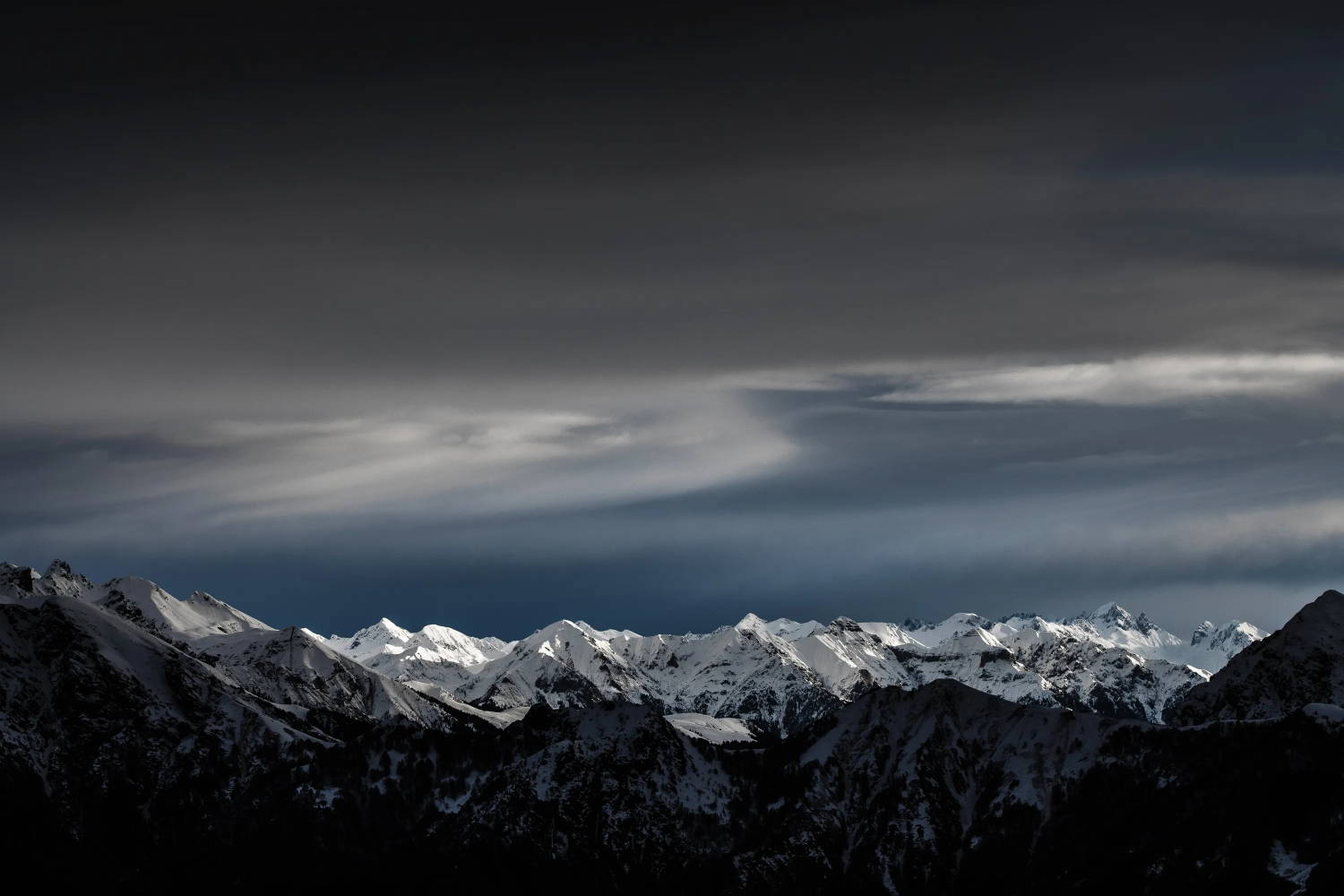 Hazy blue and grey skies above a snowy mountain range