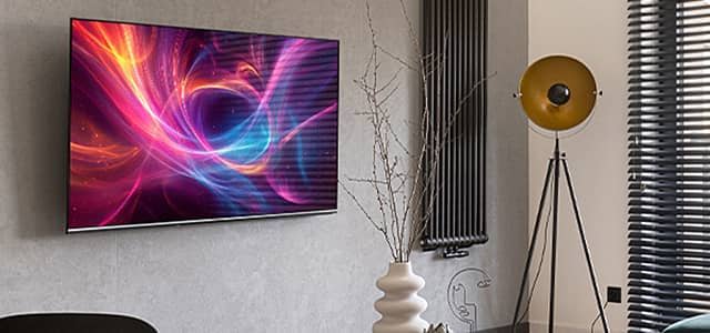 Modern living room with a TV displaying colorful abstract art and stylish decor.