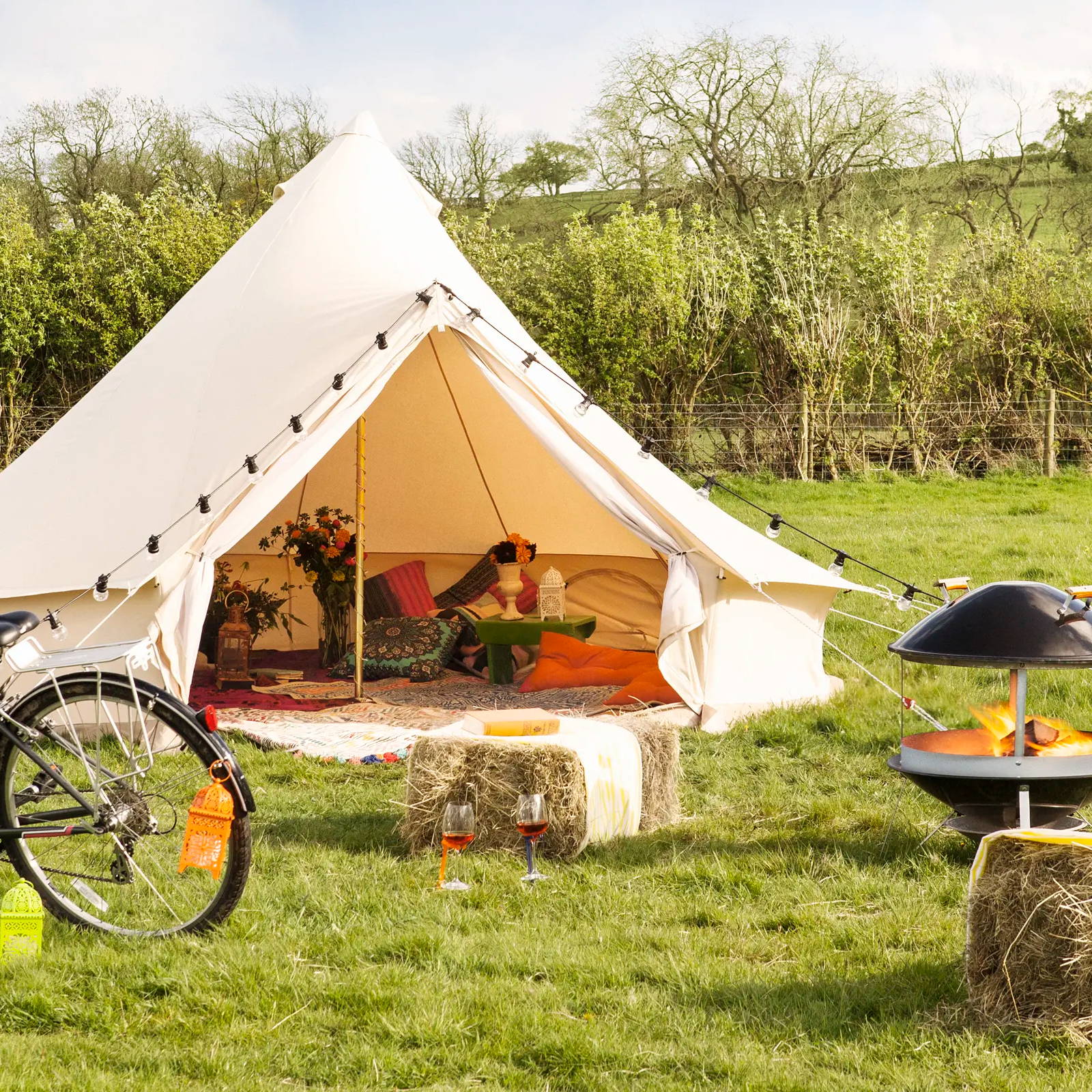 Camping setting with tent featuring festoons and lanterns