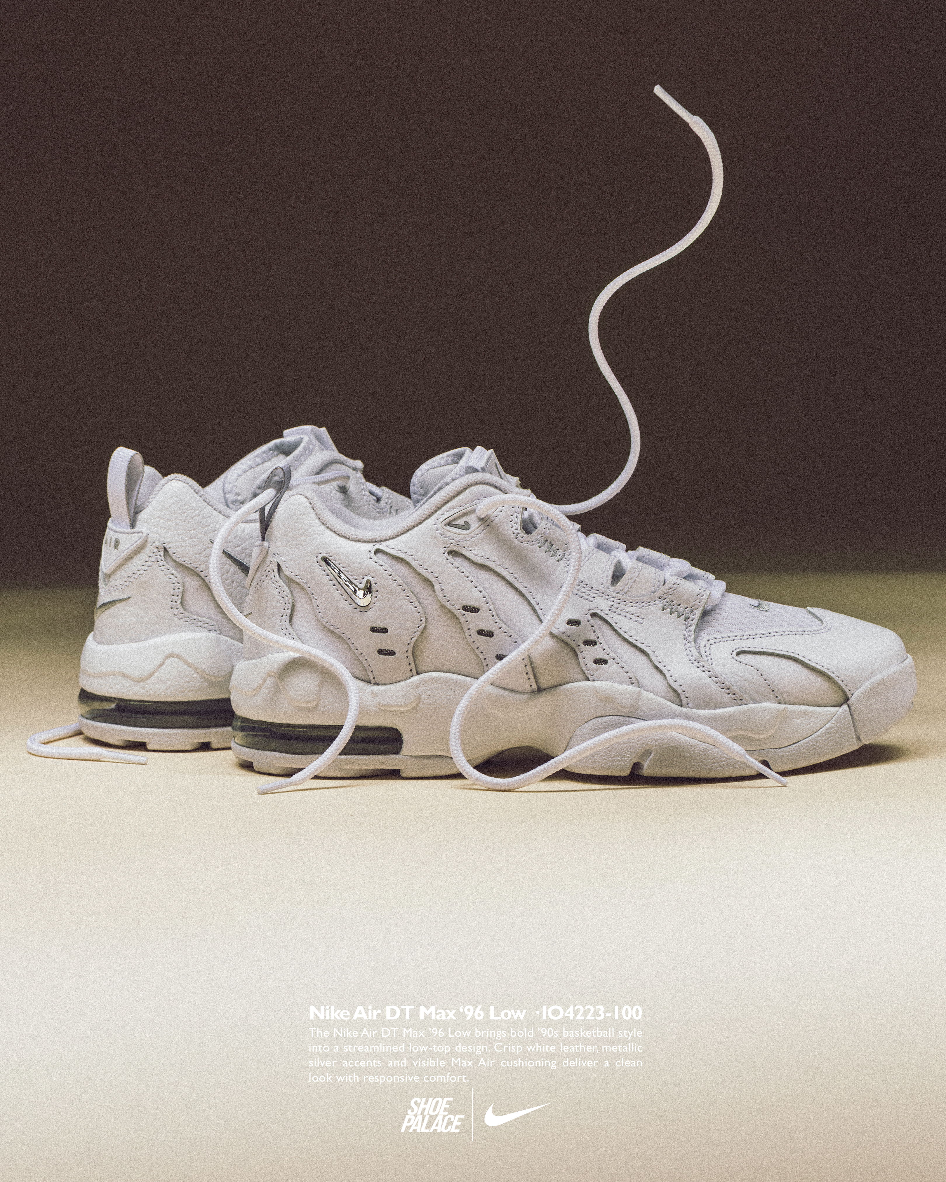 White sneakers with untied laces on a simple background.