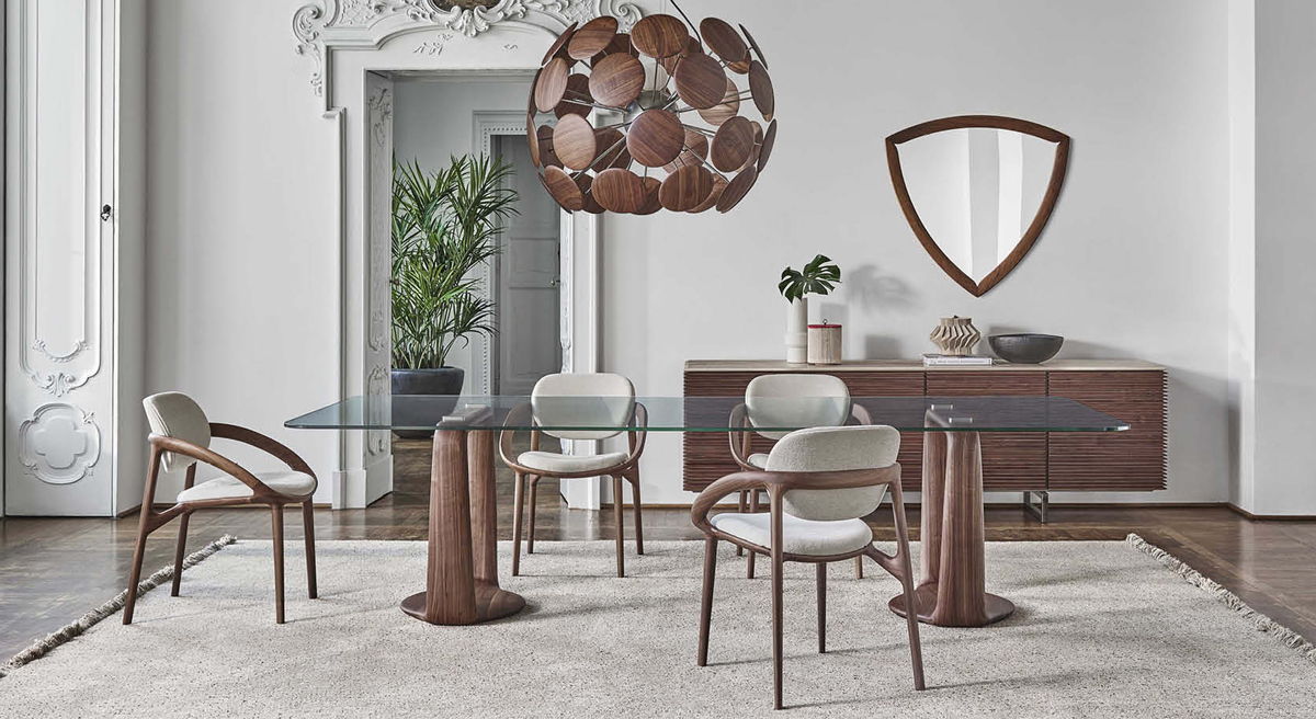 Modern Porada dining room with a glass Saddle table, stylish chairs, and decorative elements.