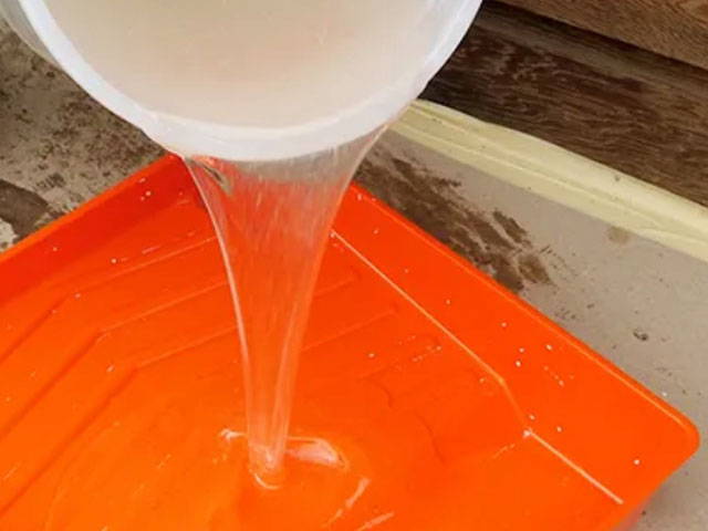 Pouring epoxy on a container.