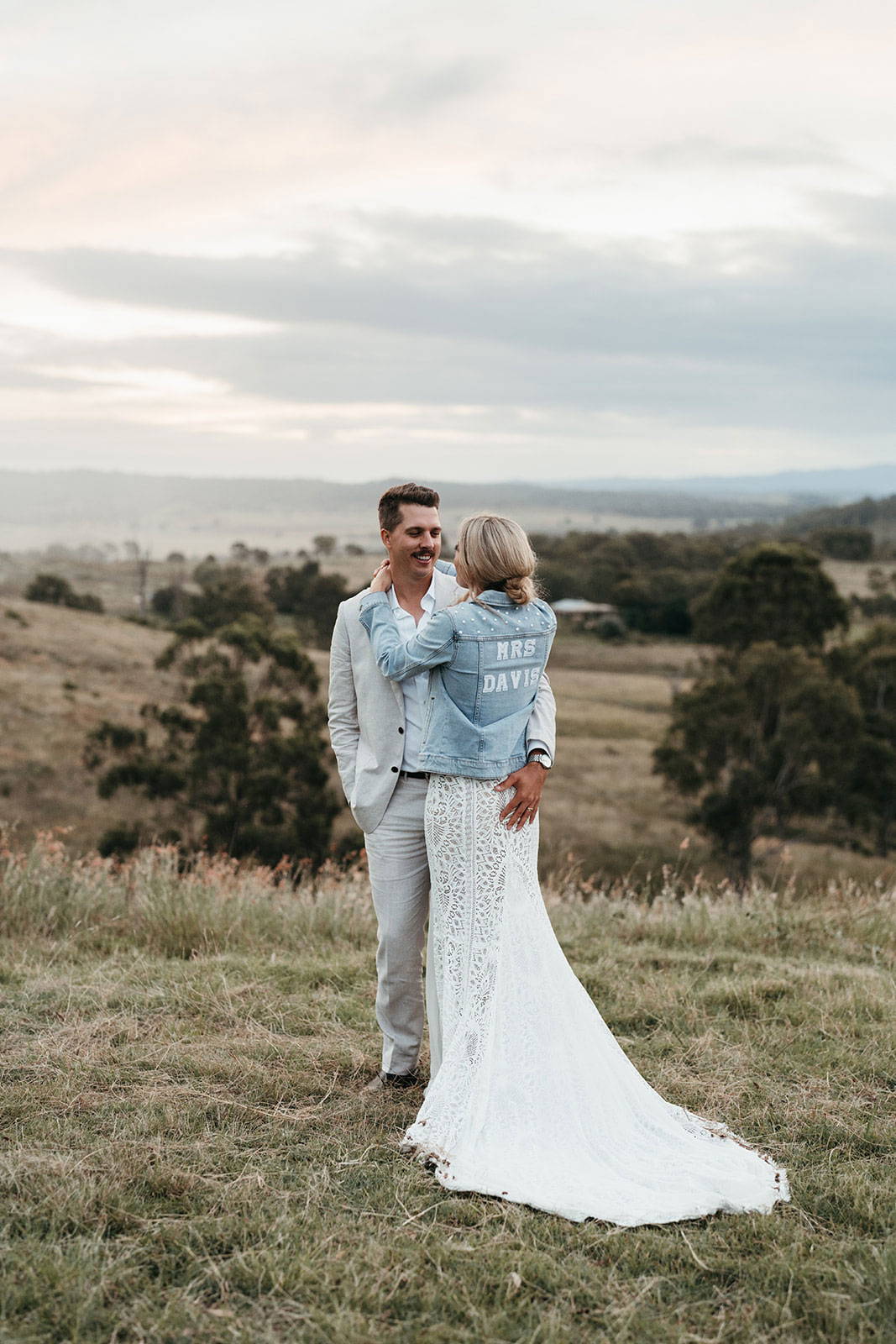 Bride with denim jacket holding Groom