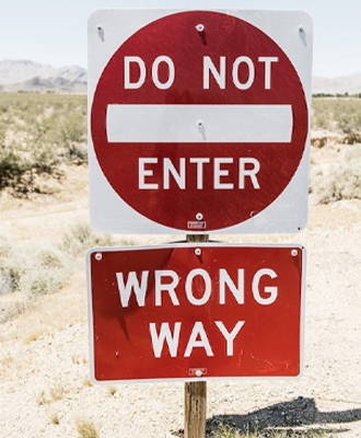 A do not enter and wrong way sign paired for enhanced visibility.