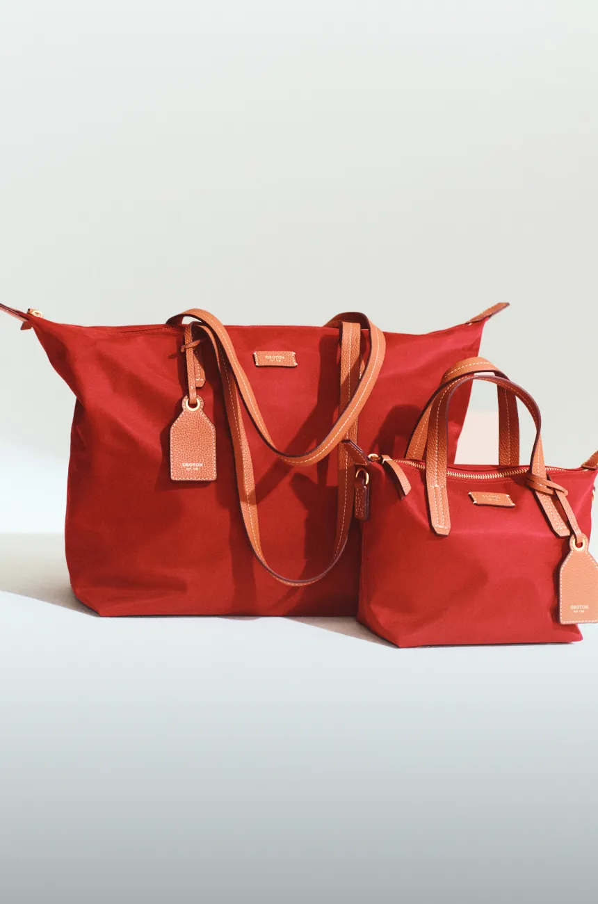 Two red handbags, one large and one small, with tags.