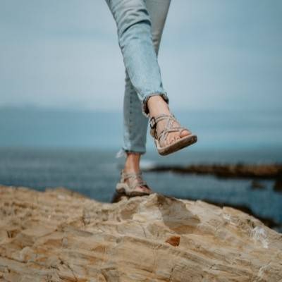 woman on rocks wearing Siena sandals
