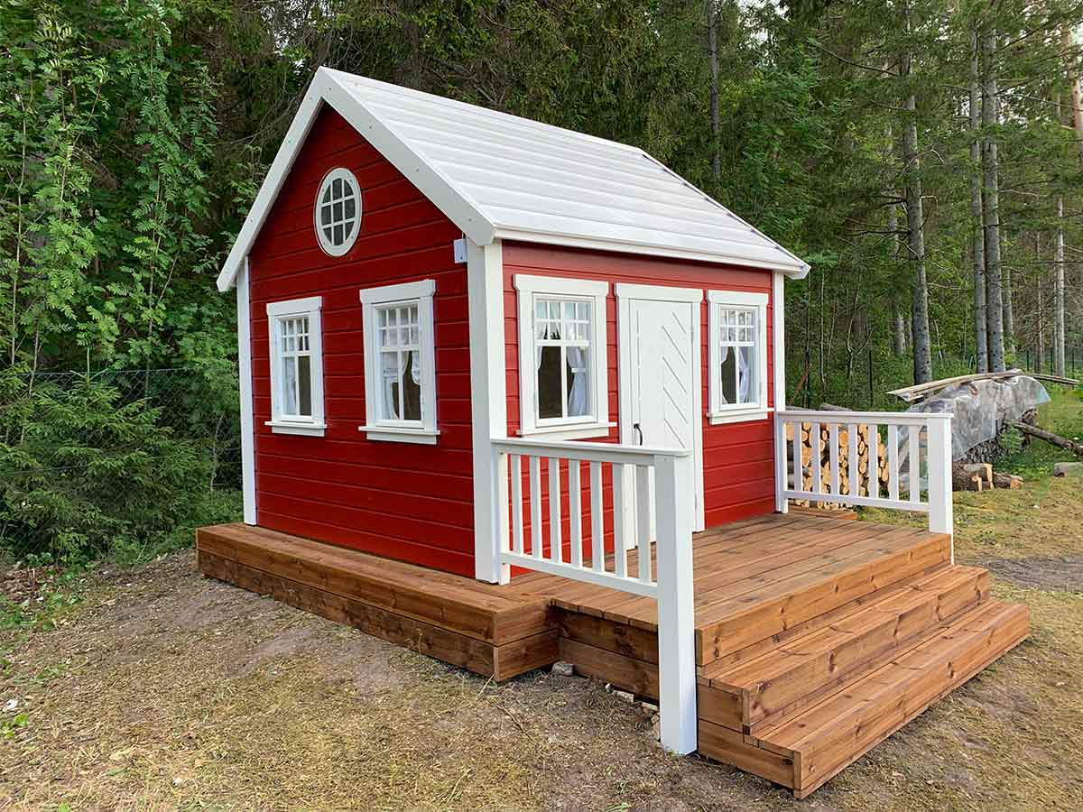 Red Wooden Custom Playhouse with white metal roof, flower boxes and wooden terrace with white railing and stairs by WholeWoodPlayhouses
