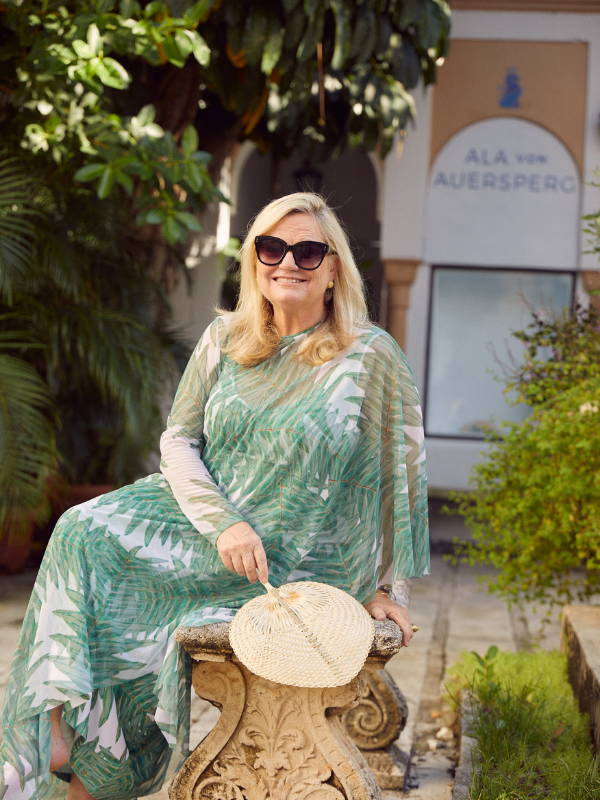 Amanda Lindroth weating green palm leaf printed mesh kaftan cover up poncho over long stretch knit green floral printed dress by Ala von Auersperg in Palm Beach Florida
