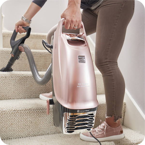 Woman using Kenmore® vacuum attachment to clean stairs