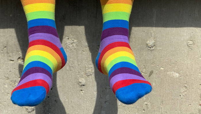 Feet hanging wearing rainbow striped socks