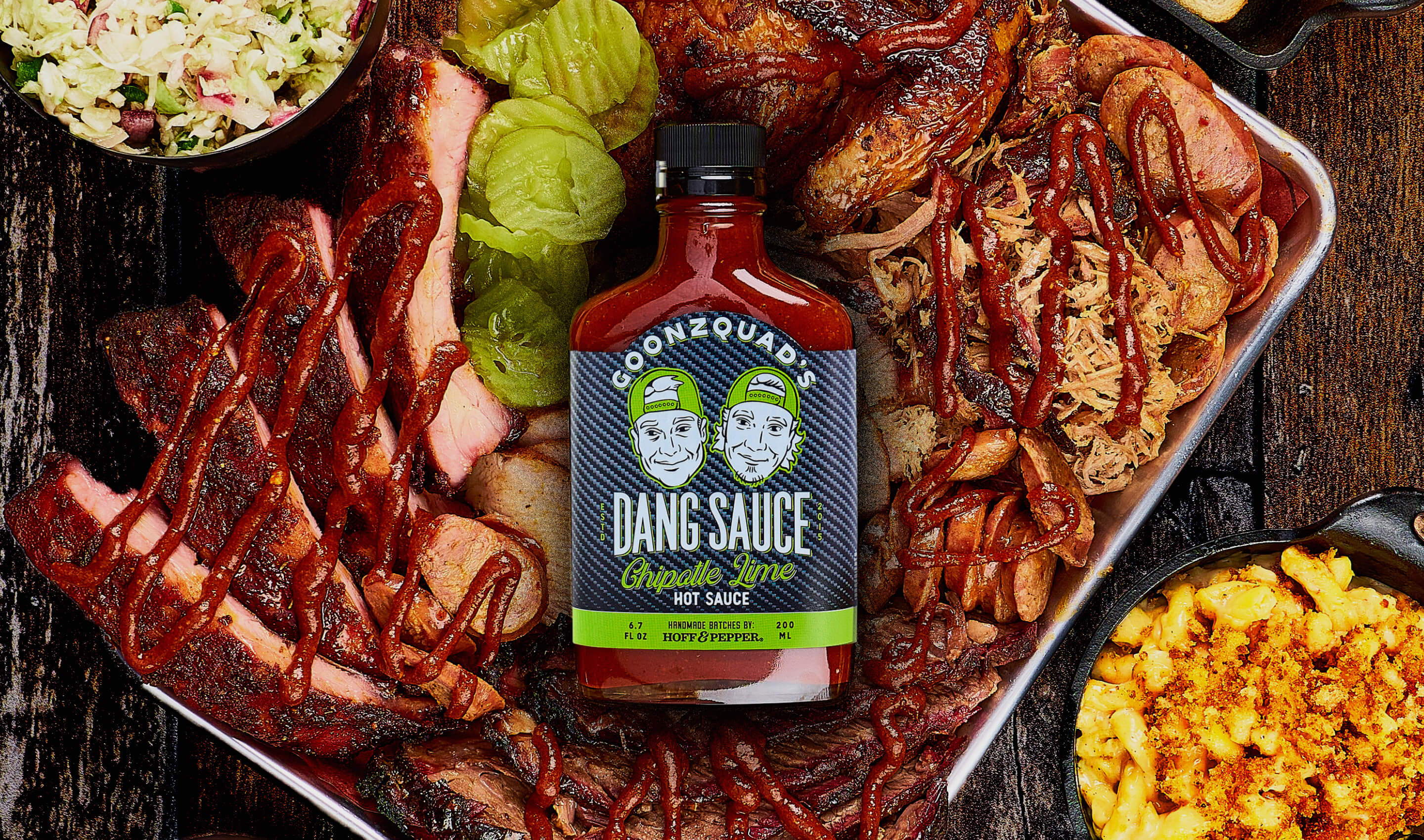 Delicious spread ofhttps://hoffandpepper.com/collections/the-dang-collection meats with bottle of Dang Sauce 
