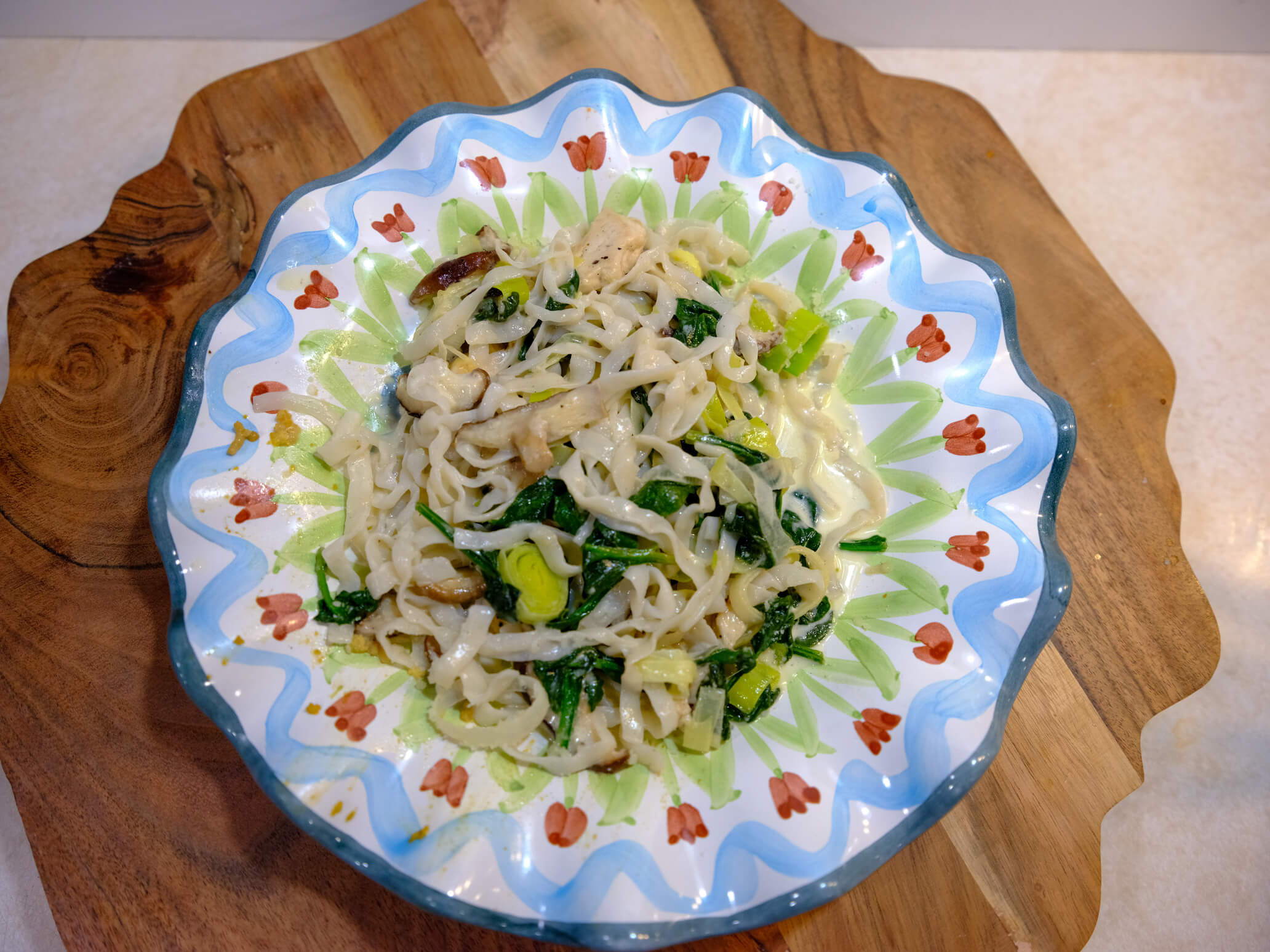 A plate full of Chicken Fettuccine pasta, made with It's Skinny noodles and tender chicken and spinach coated in a creamy sauce.