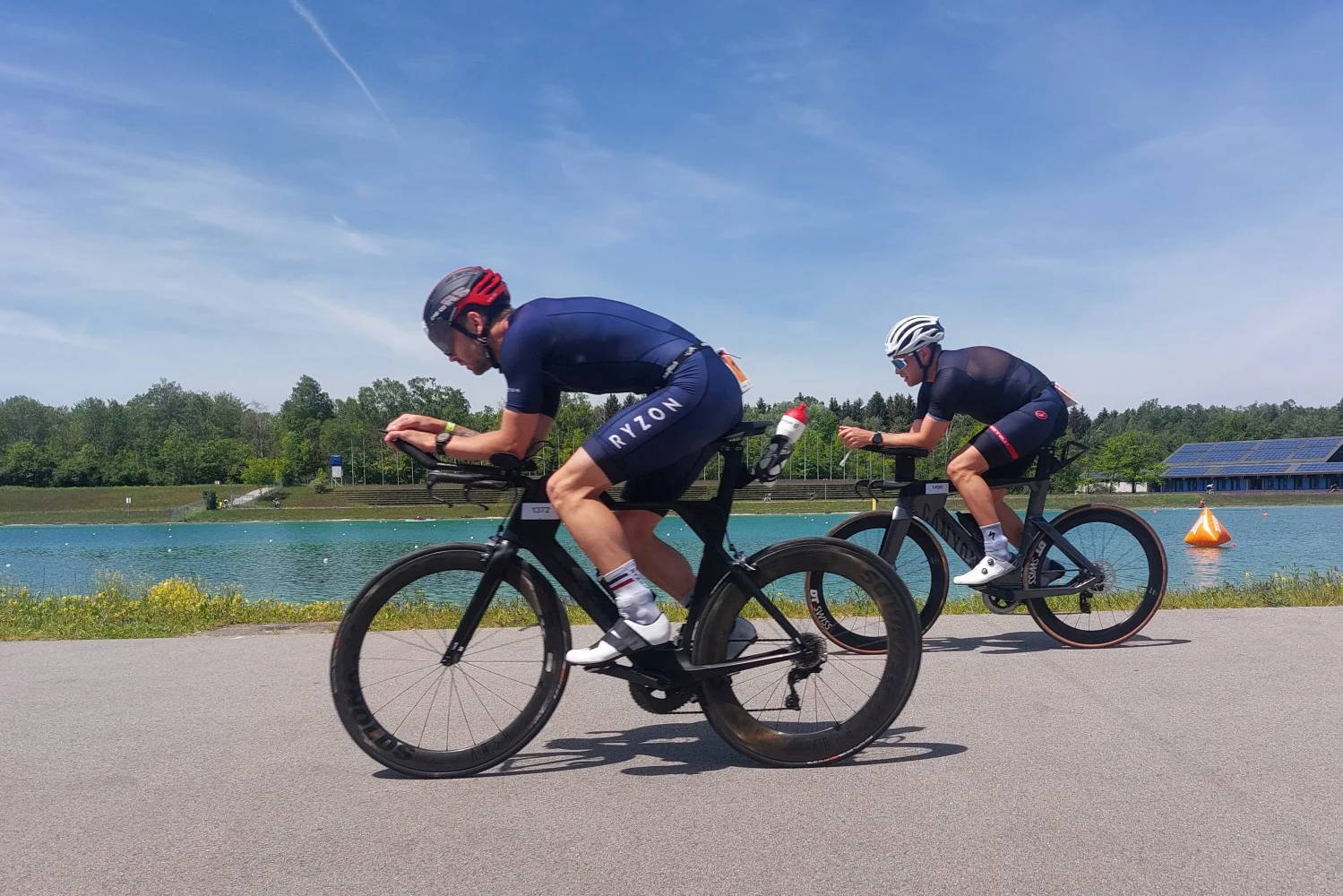 Ein Triathlet überholt einen anderen auf dem Fahrrad, Ansicht von der Seite