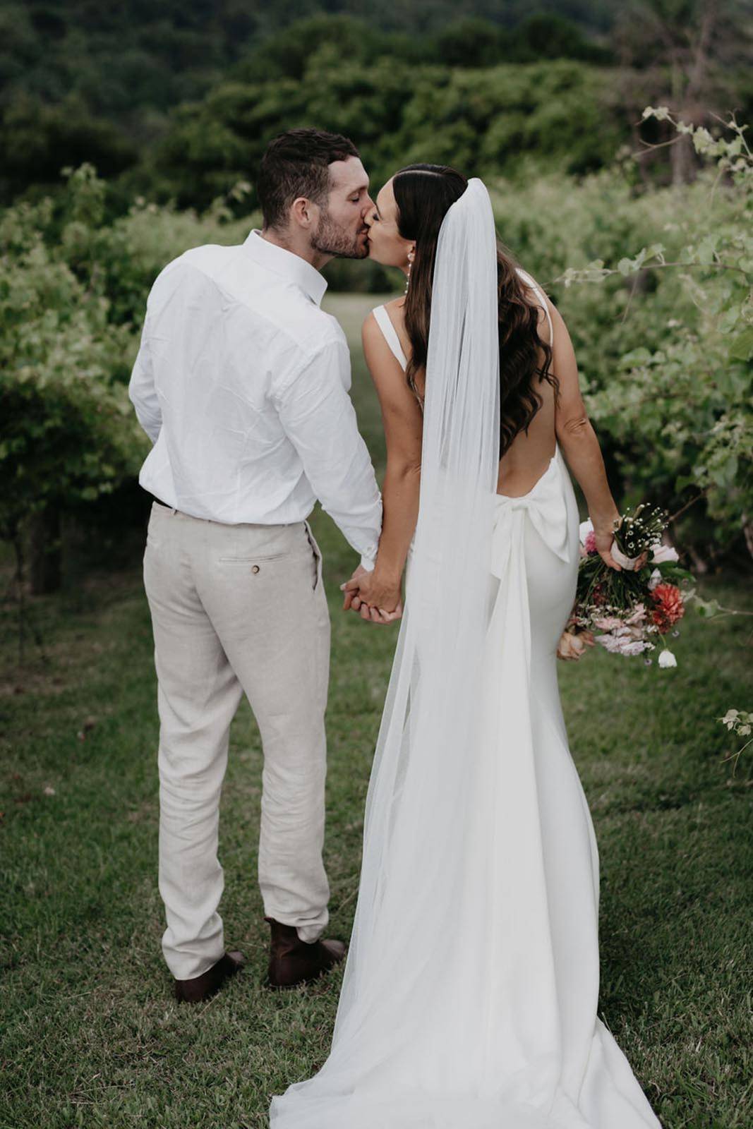 Bride and groom sharing a kiss from back