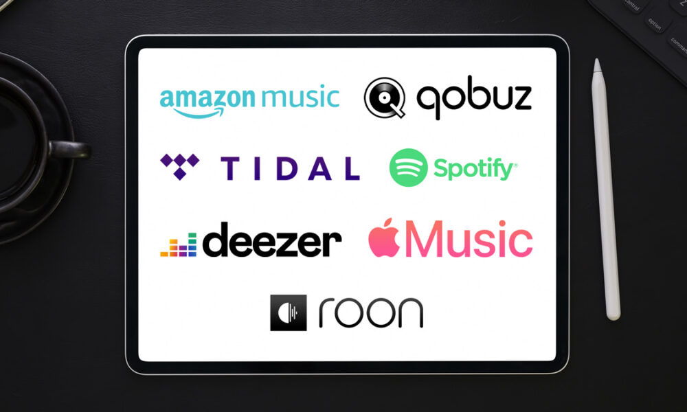 Logos of various music streaming services on a tablet.