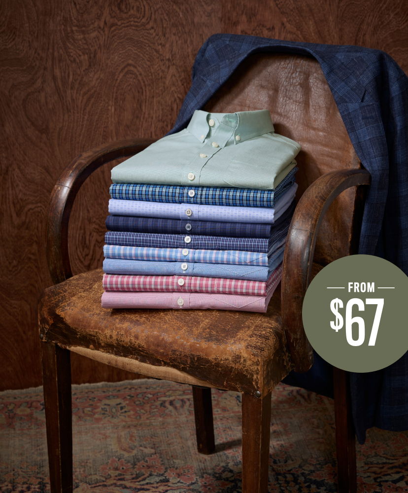 A stack of shirts on a chair with a price tag.
