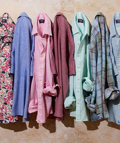 Colorful shirts hanging on a wall in various patterns and styles.