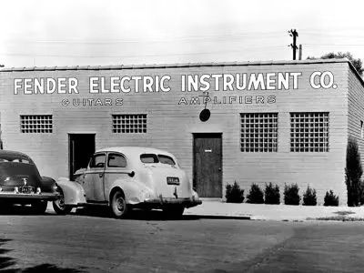 Fender Electric Instrument Co. building with parked car in black and white.